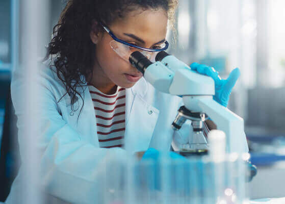 Scientist using microscope in laboratory facility